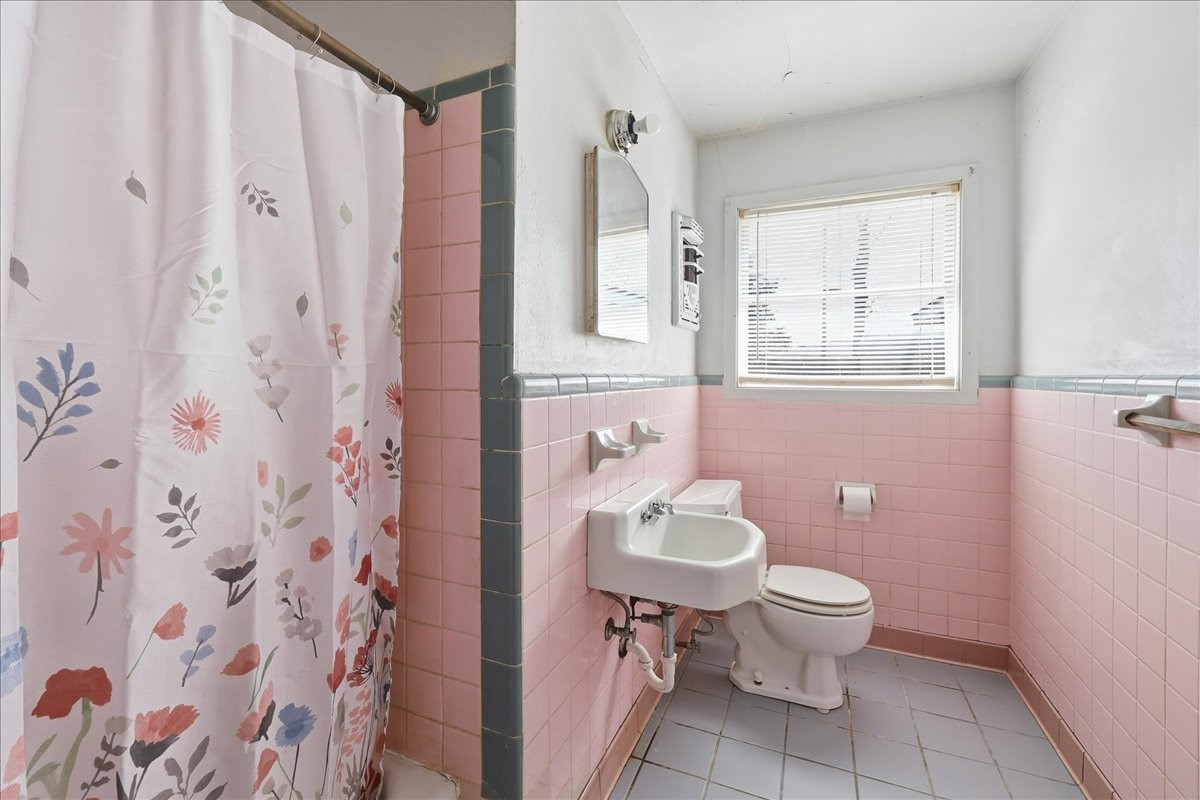 1709 West Robin Avenue Orange, TX 77632 - Photo 14 of 24 a white toilet sitting next to a bathroom sink