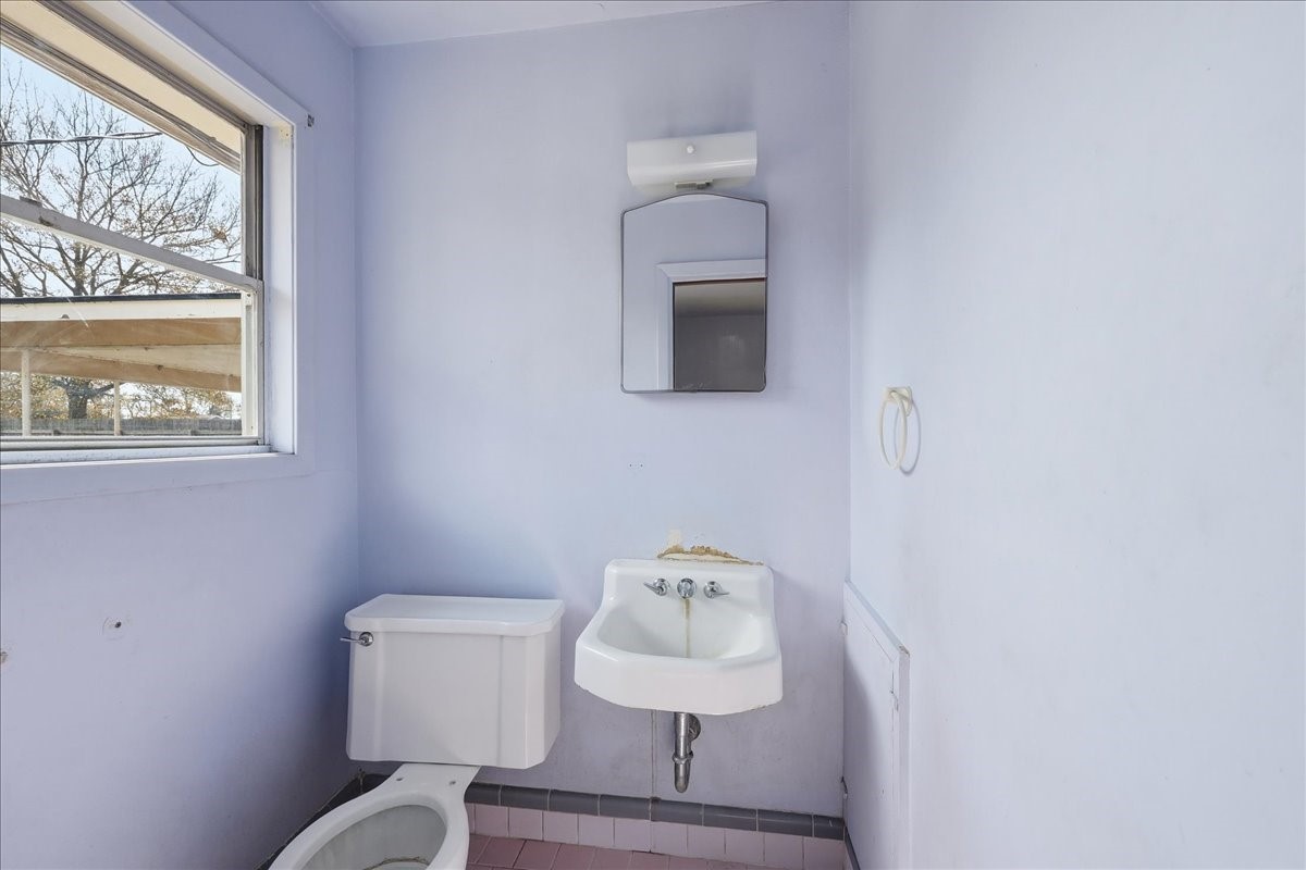 1709 West Robin Avenue Orange, TX 77632 - Photo 19 of 24 a bathroom with a toilet sink and mirror
