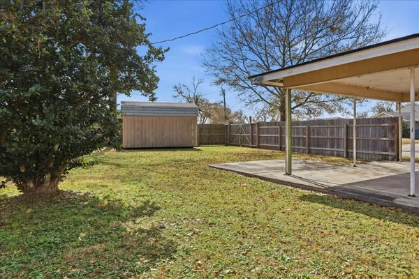 a view of a back yard with wooden fence