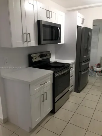 a kitchen with stainless steel appliances granite countertop a stove microwave and refrigerator