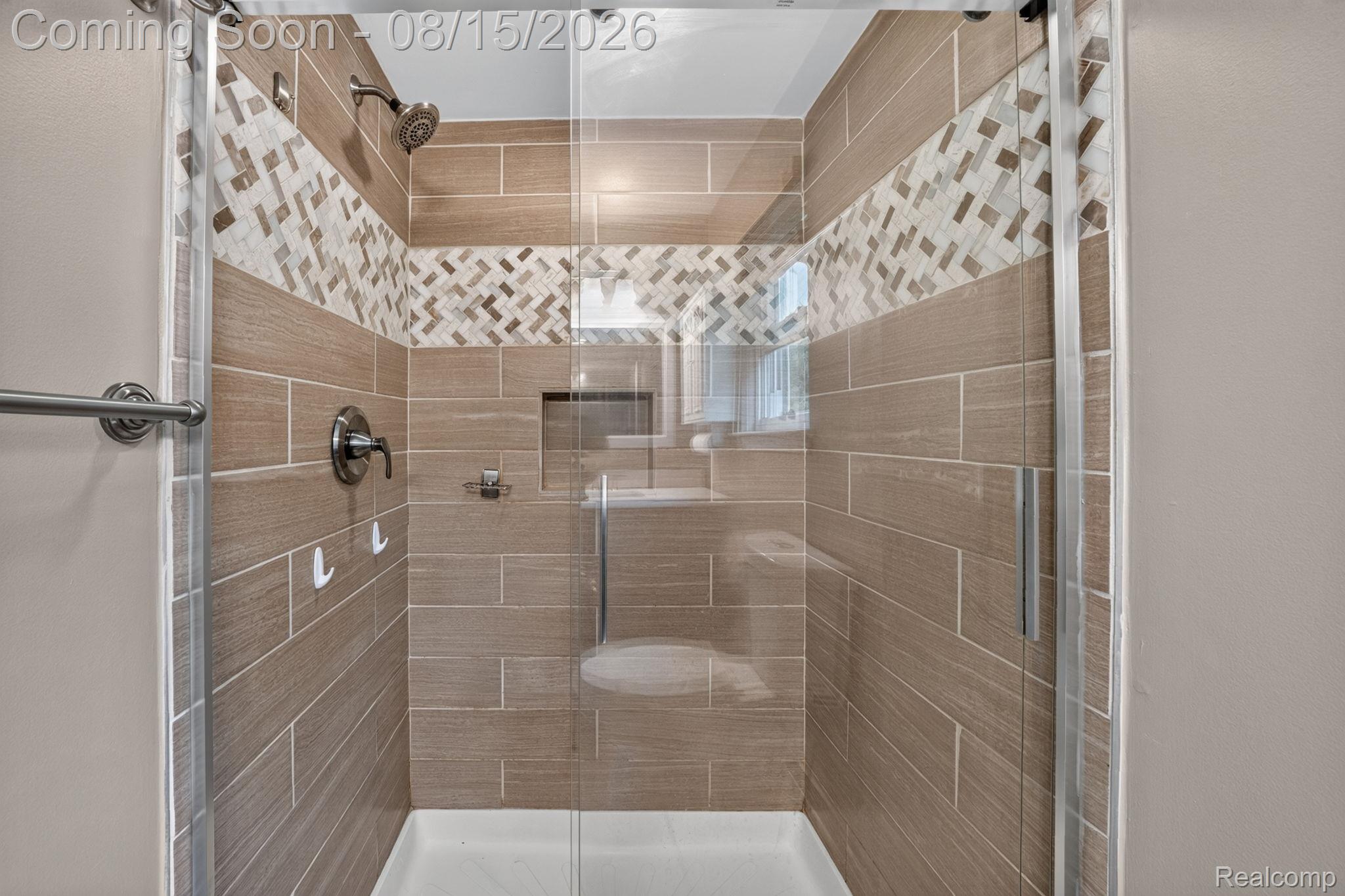 385 Arlington Drive Rochester, MI 48307 - Photo 45 of 47 Glass-enclosed shower with a decorative tile inlay band, recessed niche, and a fixed showerhead