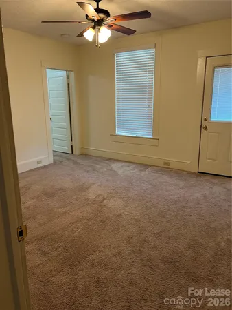 en empty room with windows and fan