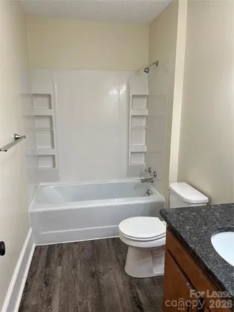 a bathroom with a granite countertop toilet a sink and bathtub