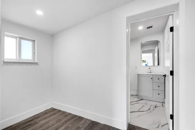 an empty room with a mirror and a sink