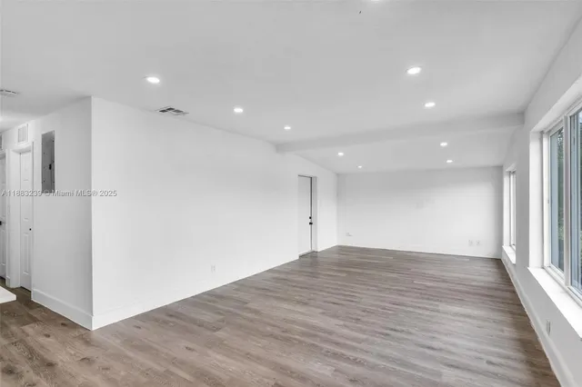 a view of an empty room with wooden floor