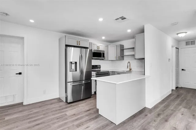 a kitchen with a refrigerator a sink and a oven