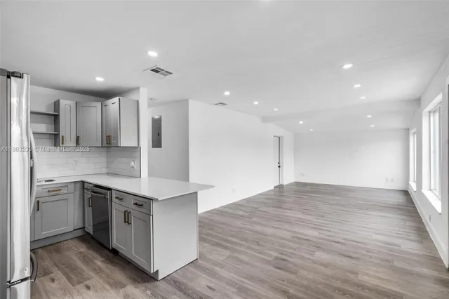 a large kitchen with stainless steel appliances granite countertop a large counter top a sink and a stove