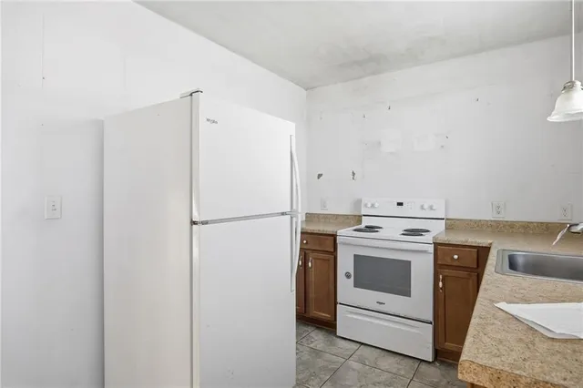 a view of a kitchen with refrigerator stove and white cabinets