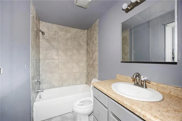 a bathroom with a granite countertop sink toilet and shower