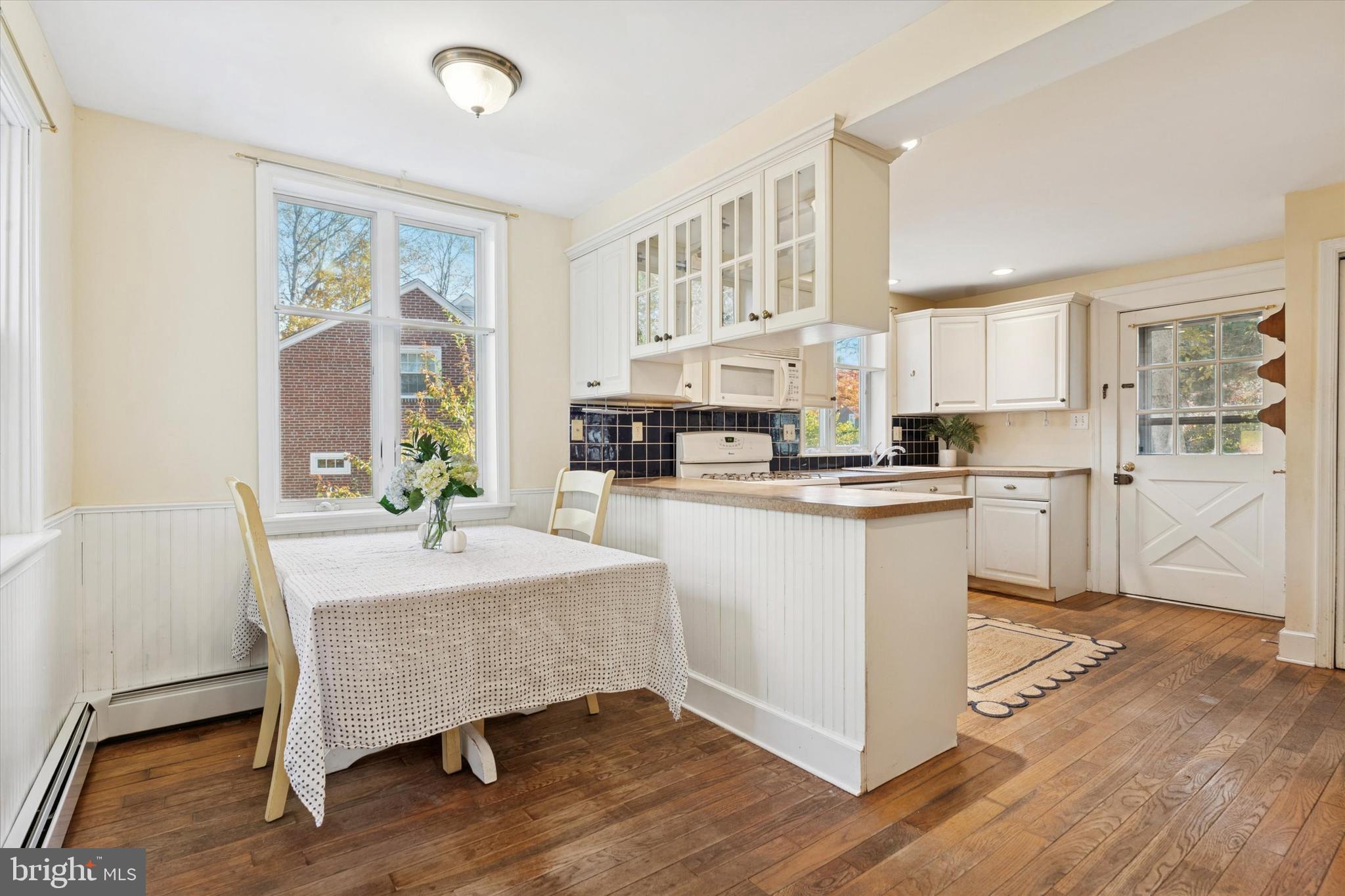 25 Green Valley Road Wallingford, PA 19086 - Photo 28 of 63 a kitchen with a refrigerator a stove cabinets dining table and chairs