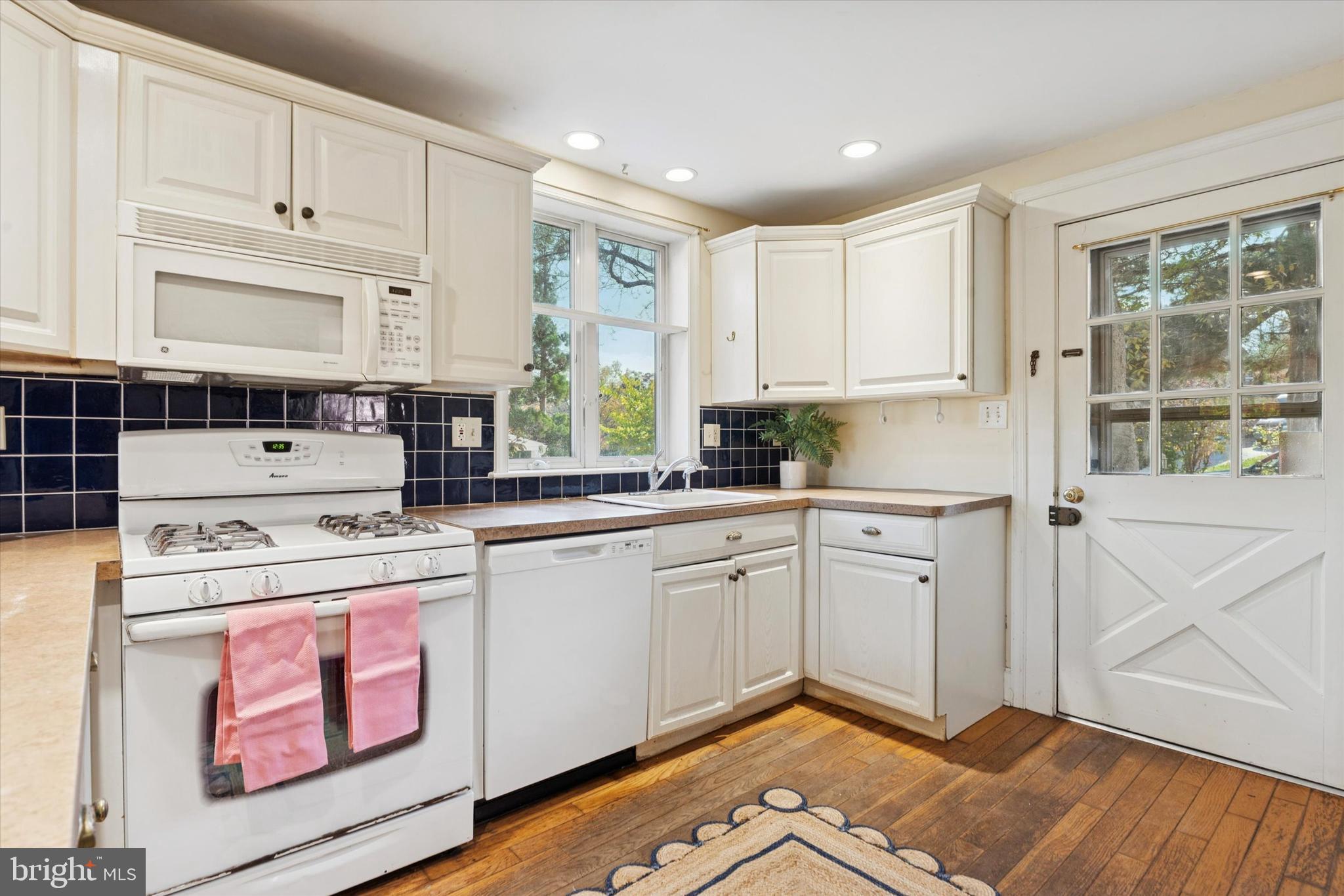 25 Green Valley Road Wallingford, PA 19086 - Photo 31 of 63 a kitchen with a stove a sink and white cabinets