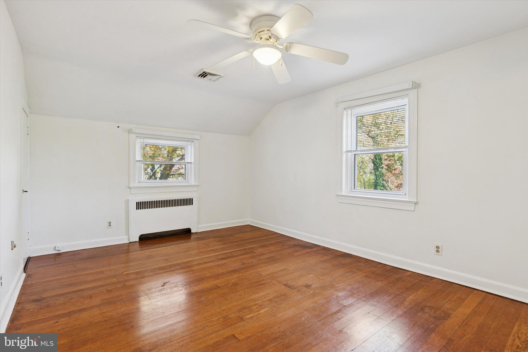 25 Green Valley Road Wallingford, PA 19086 - Photo 35 of 63 a view of an empty room with a window and wooden floor
