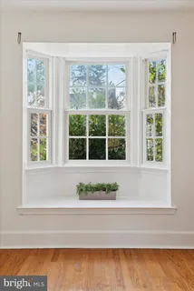 a view of a house with a yard and large tree