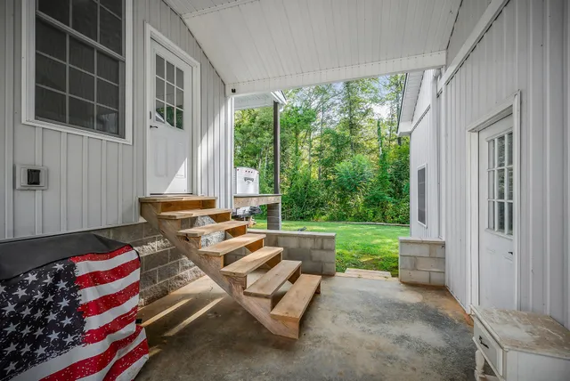 a living room with furniture a flat screen tv and a large window