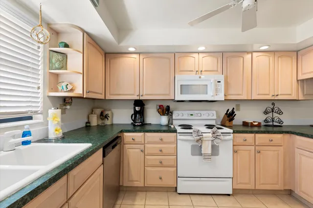 a kitchen with white cabinets and white appliances