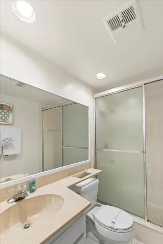 a bathroom with a sink toilet vanity and shower