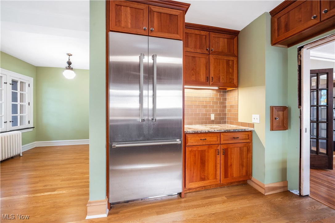 24510 Lake Road Bay Village, OH 44140 - Photo 22 of 45 Kitchen featuring built in fridge, tasteful backsplash, light wood finished floors, light stone counters, and french doors