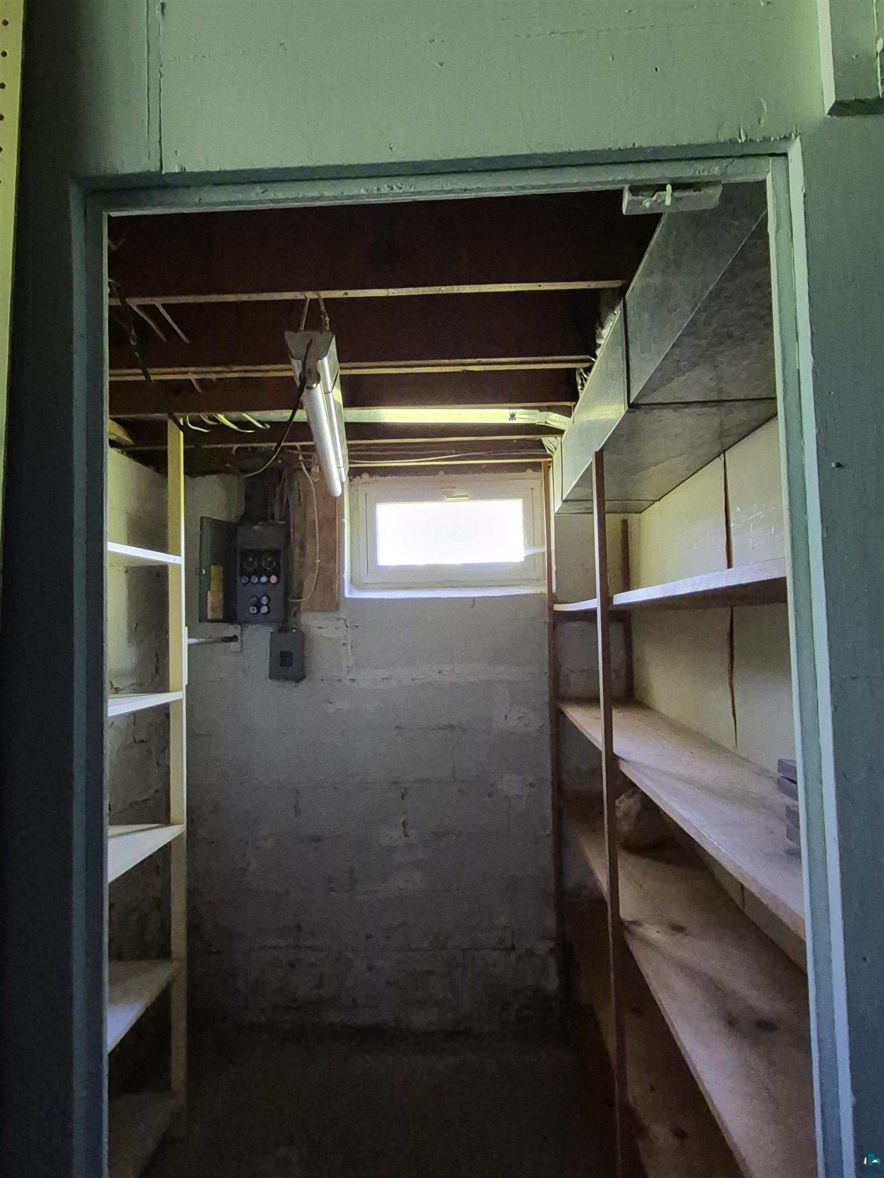 2109 West 22nd Street Duluth, MN 55811 - Photo 22 of 29 Basement storage area featuring exposed ceiling joists, concrete block walls, and a small window