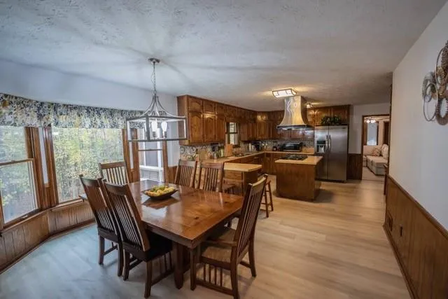 a dining room with furniture a chandelier and wooden floor