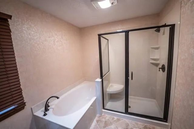 a bathroom with a white bathtub a shower and a sink