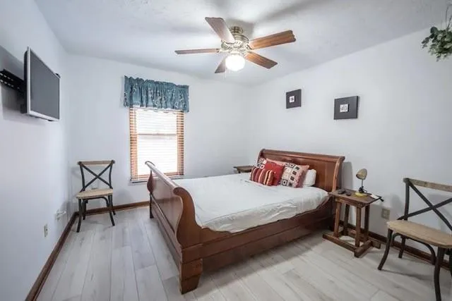 a bedroom with a bed a chair and a large window