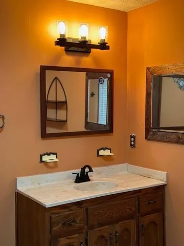 a bathroom with a sink vanity and mirror