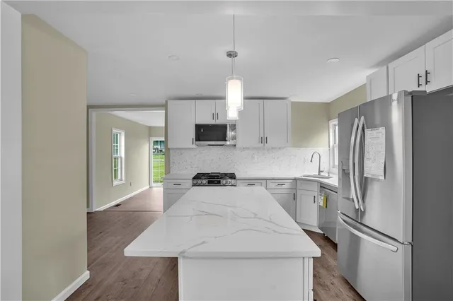 a kitchen with a refrigerator sink and cabinets