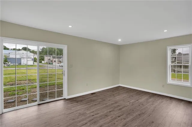 a view of a big room with wooden floor and windows