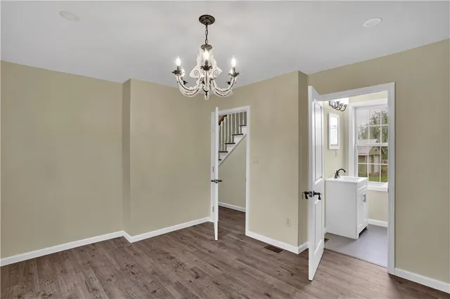 a view of a room with wooden floor and chandelier