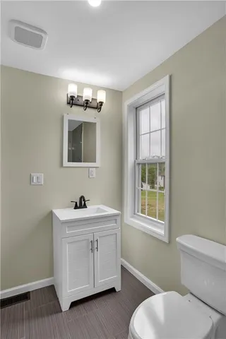 a bathroom with a sink a toilet and mirror