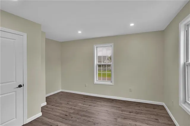 an empty room with wooden floor and a window