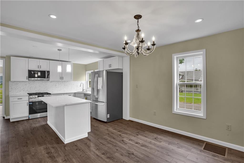 46 Terrace Road Millsboro, PA 15348 - Photo 9 of 32 a kitchen with stainless steel appliances granite countertop a refrigerator a stove oven a sink dishwasher and white cabinets with wooden floor
