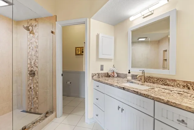 a bathroom with a granite countertop sink a shower and a mirror