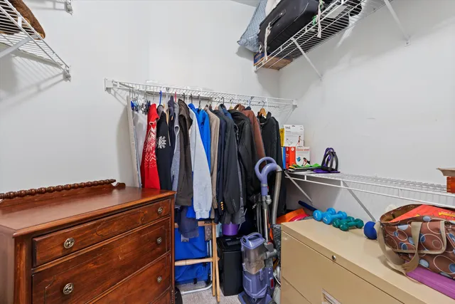 a view of walk in closet with clothes and shoes