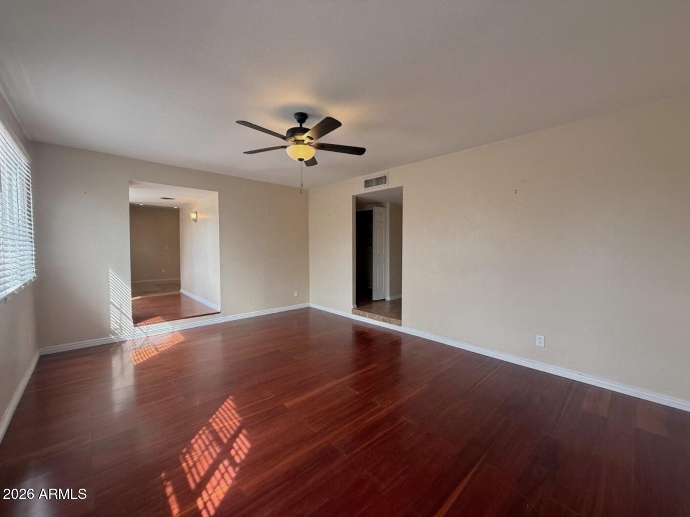 4625 South Rita Lane Tempe, AZ 85282 - Photo 7 of 16 a view of an empty room with a window and wooden floor