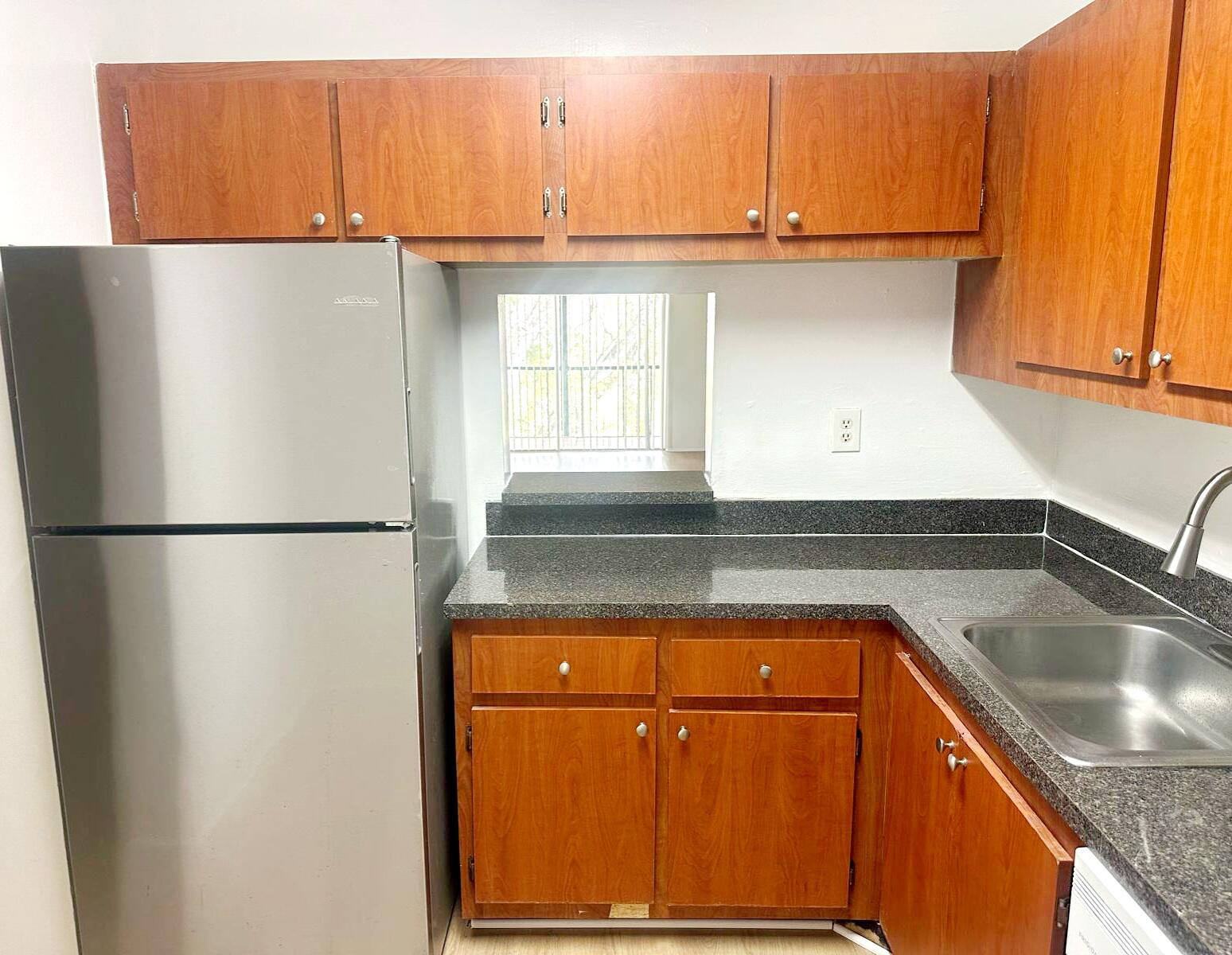 7911 North Colony Circle, Unit 305 Tamarac, FL 33321 - Photo 12 of 49 a kitchen with a refrigerator and a sink