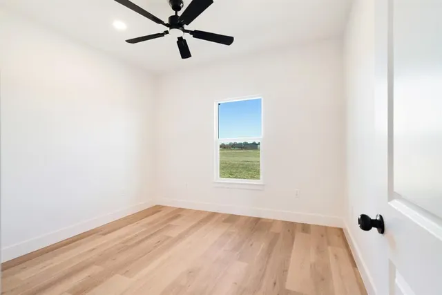 a view of a room with a window and a ceiling fan
