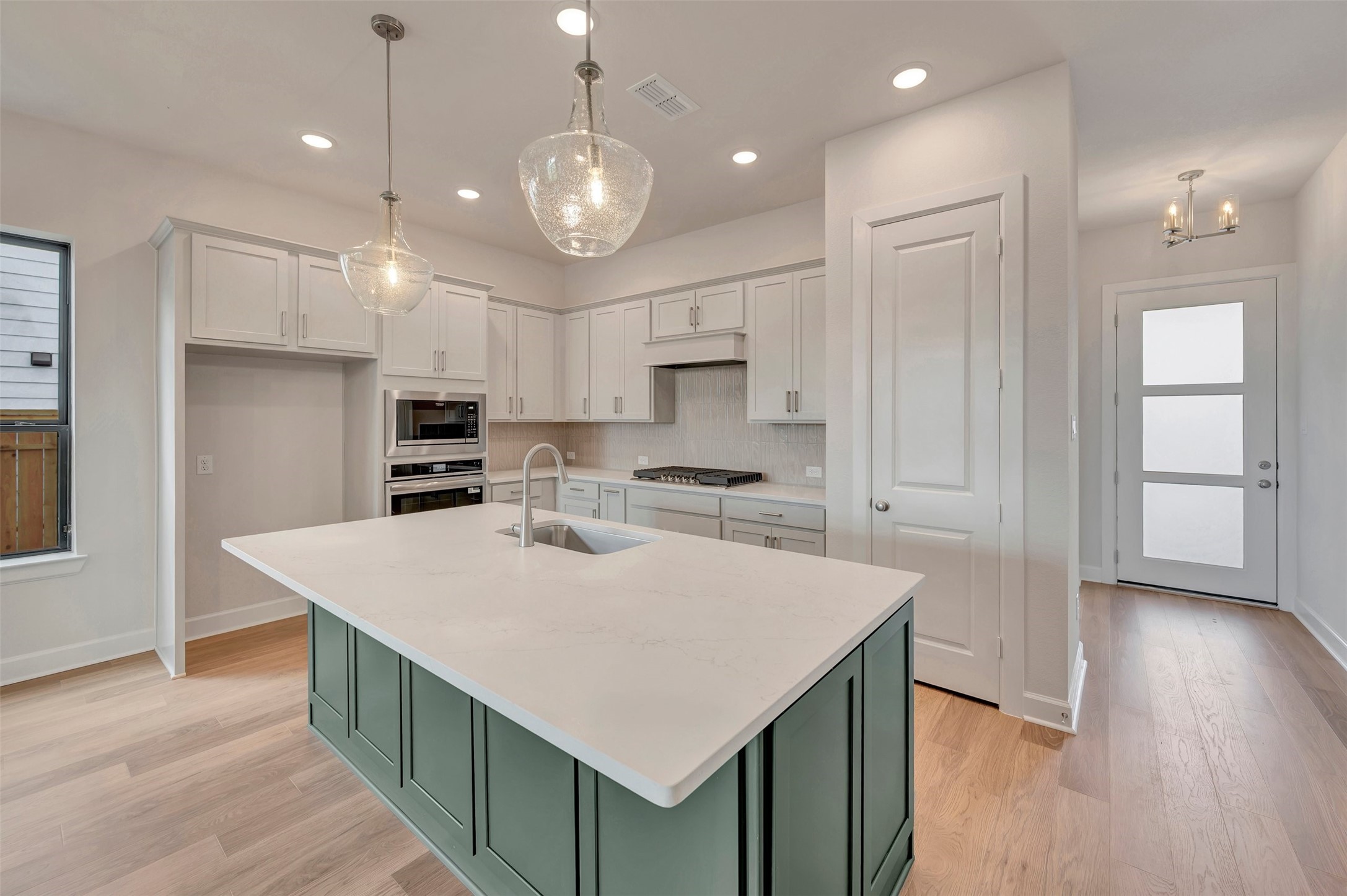 2718 Cottage Place Rosharon, TX 77583 - Photo 20 of 50 an open kitchen with kitchen island wooden floor center island and stainless steel appliances