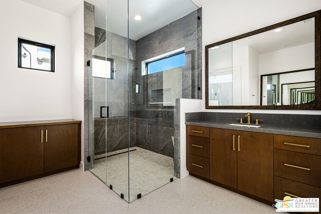 4 Heliotrope Avenue, Unit LOT #299 Rancho Mirage, CA 92270 - Photo 17 of 18 a bathroom with a shower sink and mirror