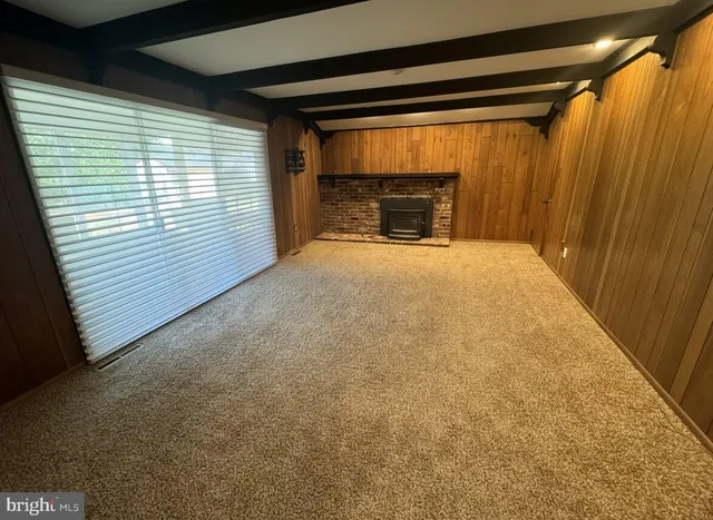 a view of empty room with a fireplace and window