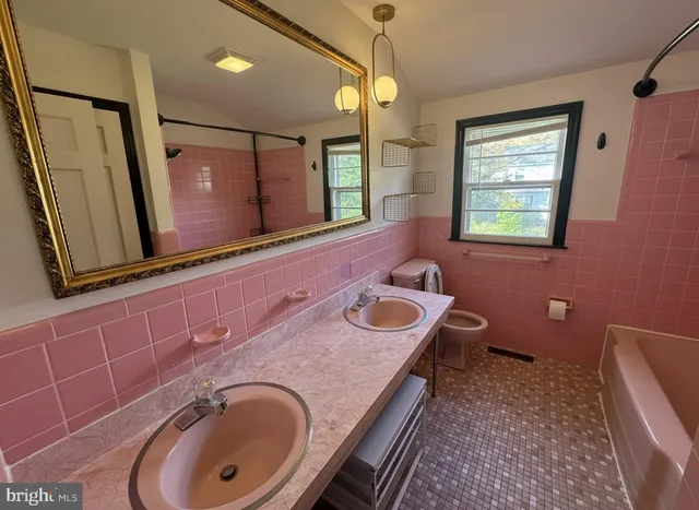 a bathroom with a granite countertop double vanity sink and a mirror