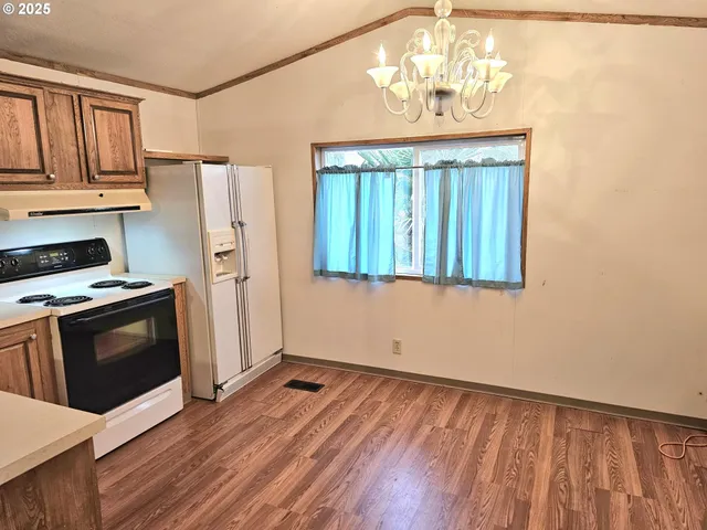 a kitchen with granite countertop wooden floors and stainless steel appliances