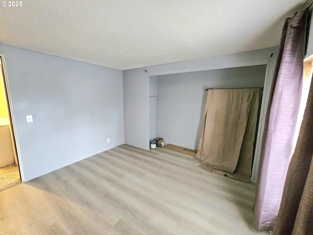 a view of a room with a refrigerator and window