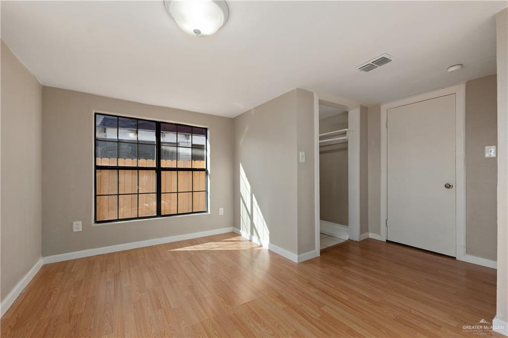 309 South 4th Street McAllen, TX 78501 - Photo 13 of 21 an empty room with wooden floor and windows