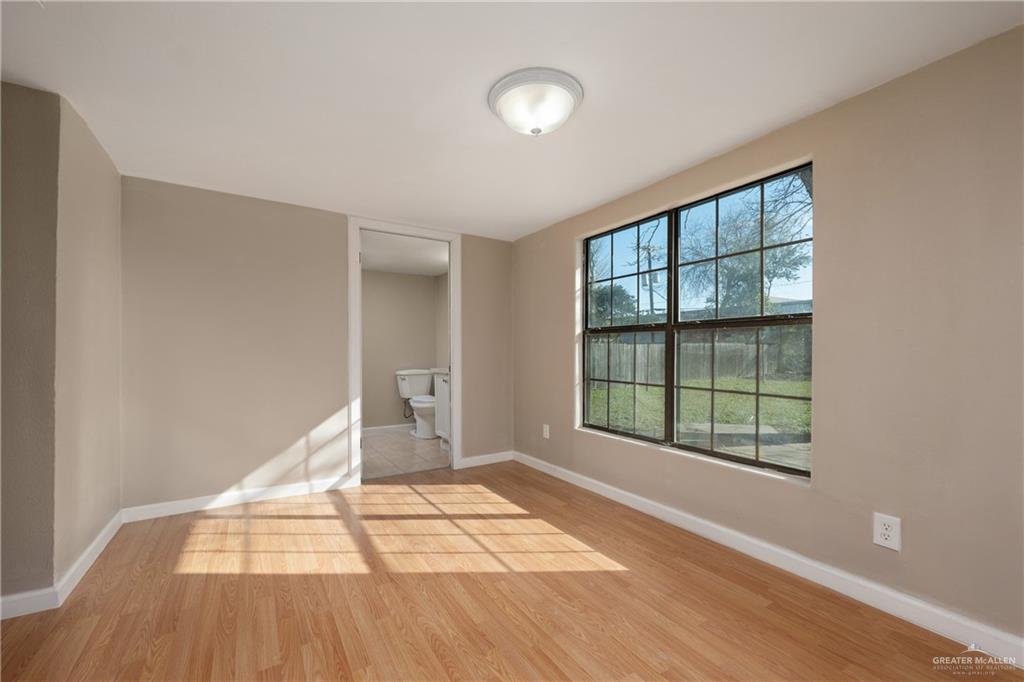 309 South 4th Street McAllen, TX 78501 - Photo 14 of 21 a view of an empty room with wooden floor and a window