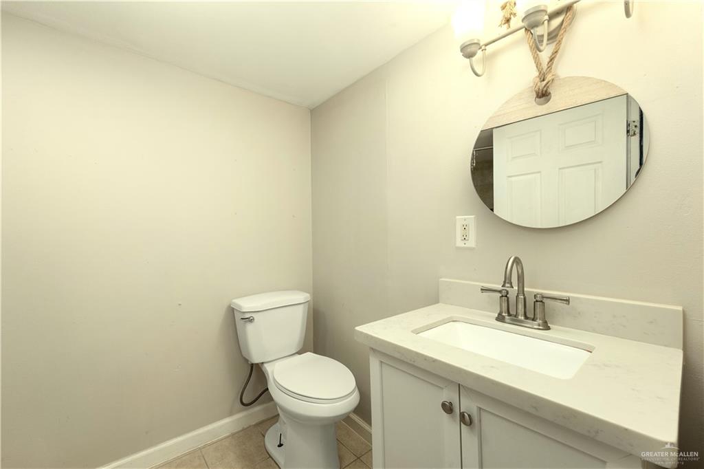 309 South 4th Street McAllen, TX 78501 - Photo 15 of 21 a bathroom with a toilet a sink and mirror