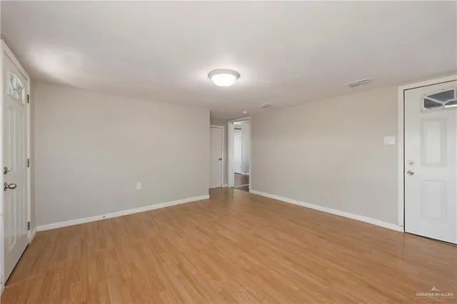 a view of an empty room with wooden floor