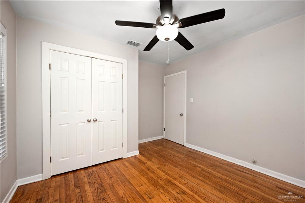 309 South 4th Street McAllen, TX 78501 - Photo 6 of 21 an empty room with wooden floor fan and windows