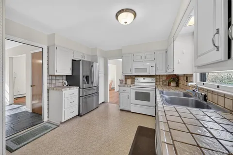 a kitchen with white cabinets and stainless steel appliances