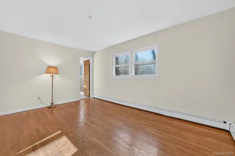 an empty room with wooden floor and window